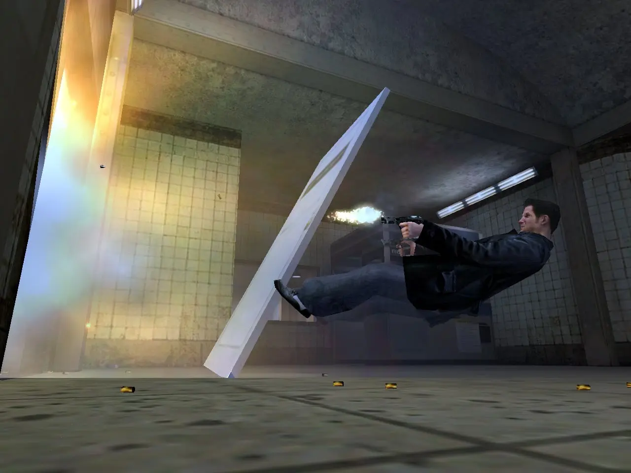 Max Payne — Max dives sideways through a subway station, firing a pistol in mid-air